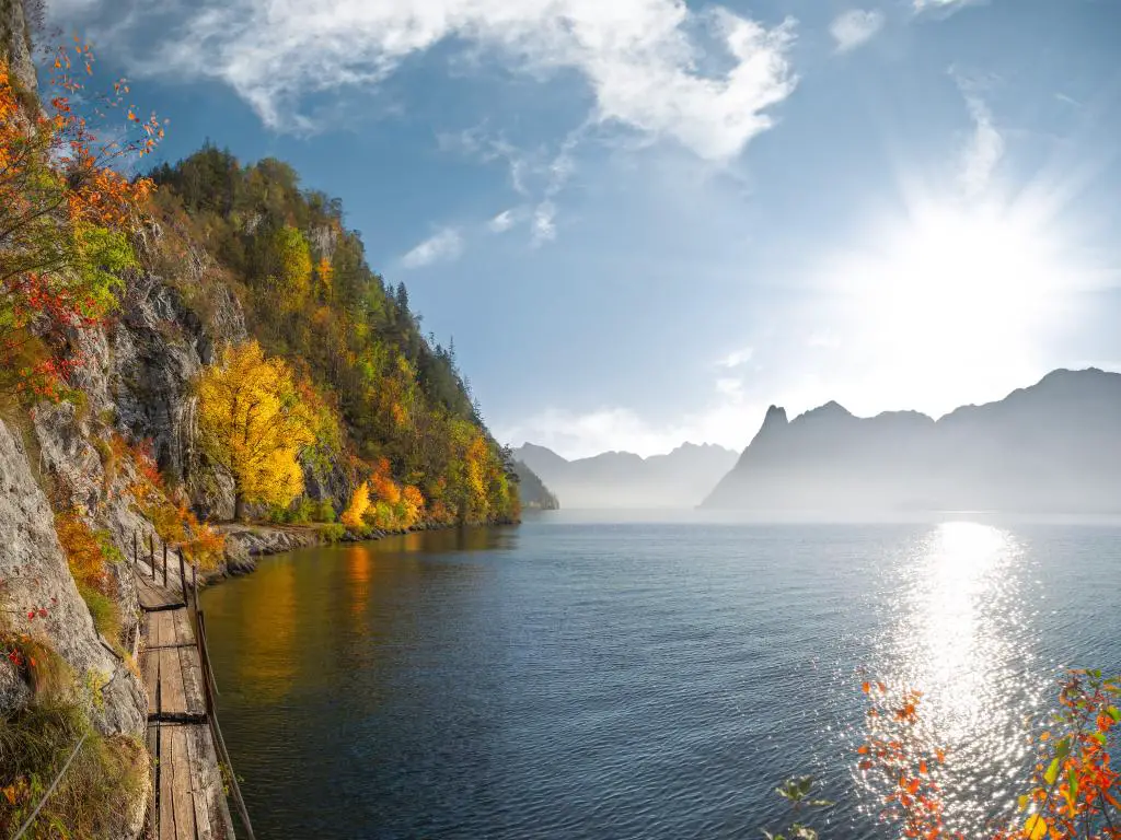 Un sendero para caminar junto a un lago en Austria rodeado de coloridas hojas de otoño y un lago resplandeciente
