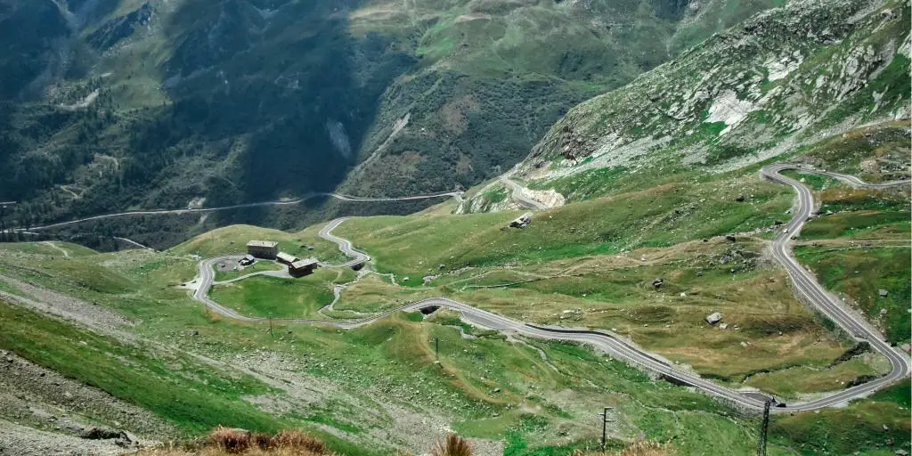 Camino sinuoso en la montaña verde Great St Bernard Pass, Suiza/Italia