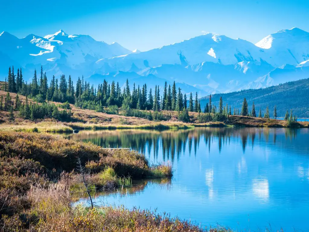 Wonder Lake en el Parque Nacional Denali, Alaska, con montañas al fondo y un cielo azul arriba