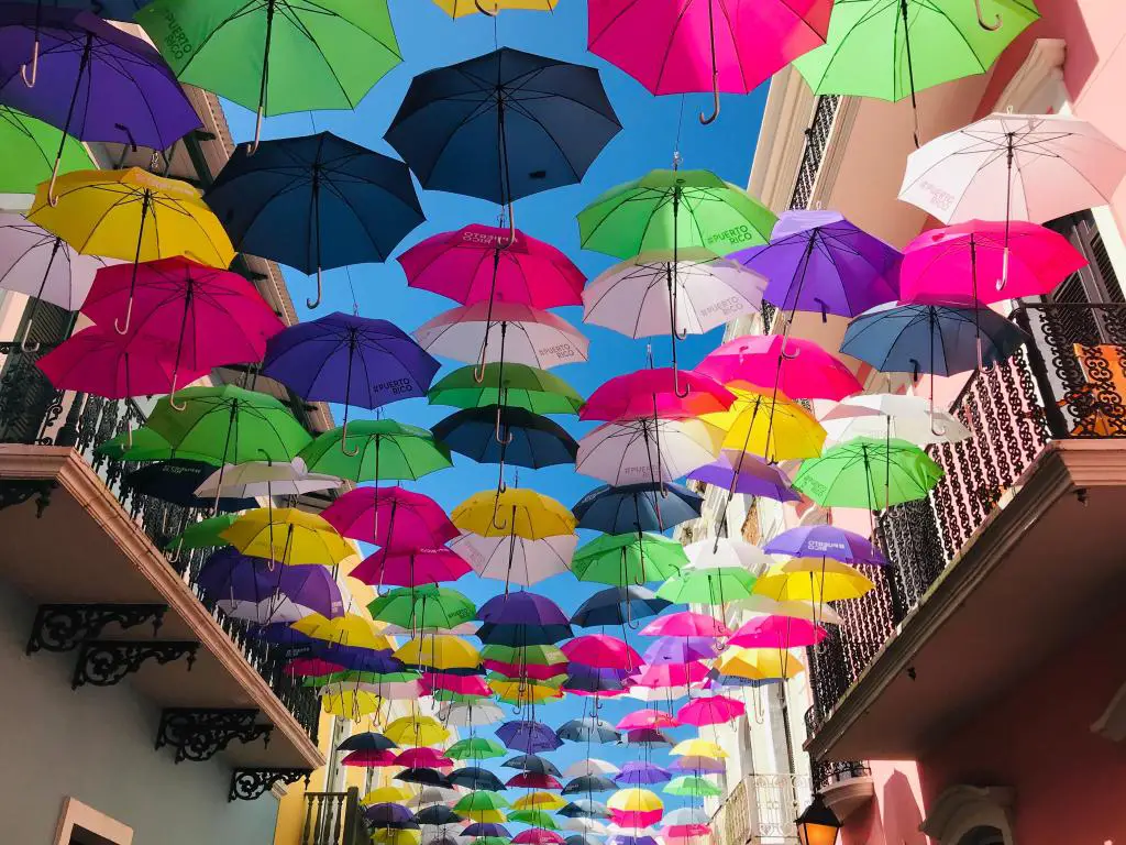 Paraguas brillantes entregando por encima de la calle en el Viejo San Juan de Puerto Rico
