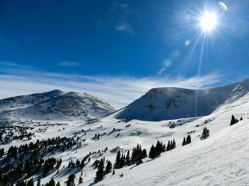 Vista de la montaña Breckenridge Colorado, con nieve brillando bajo el sol brillante y un cielo azul arriba