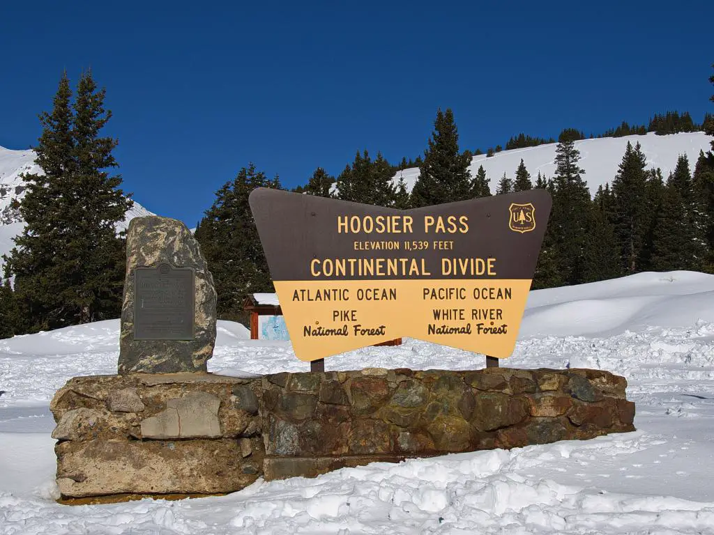 Servicio Forestal del Departamento de Agricultura signo que marca la divisoria continental en Hoosier Pass cerca de Breckenridge Colorado con nieve alrededor