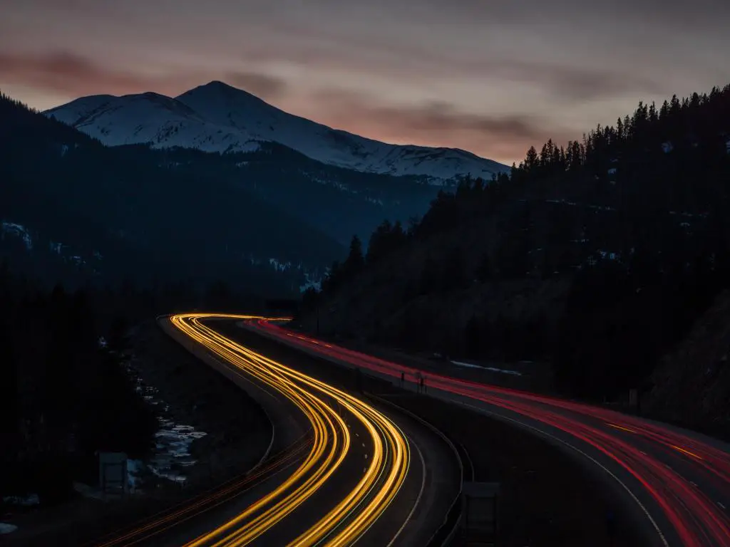 I-70 que atraviesa las Montañas Rocosas cerca de Silver Plume, Colorado.  Disparo de larga exposición en la noche con luces traseras  