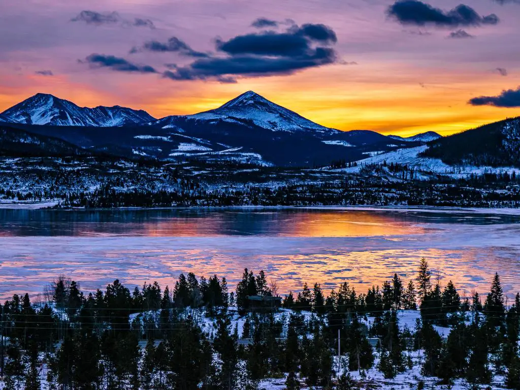 Amanecer sobre Breckenridge, Colorado, con un cielo de tonos púrpura y naranja y montañas en el fondo