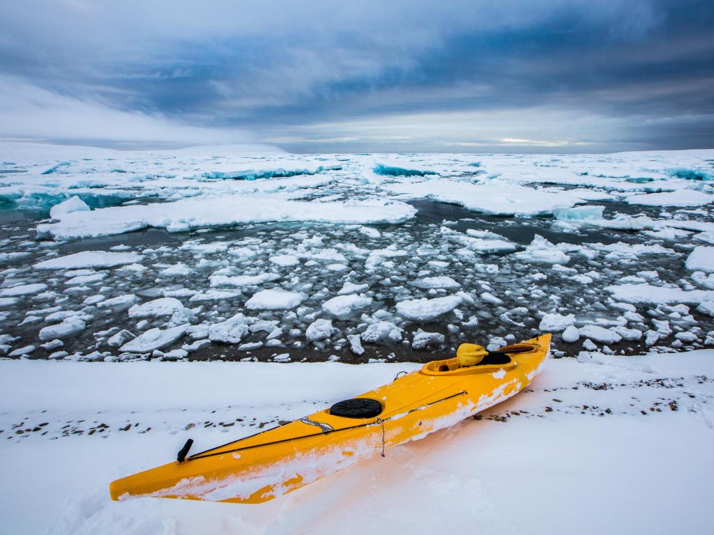 Un kayak amarillo en el agua congelada en Nunavut, Canadá