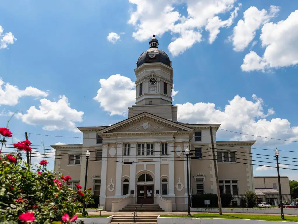 Vista del histórico juzgado del condado de Claiborne en Port Gibson, Mississippi, en un día soleado con flores rojas en primer plano