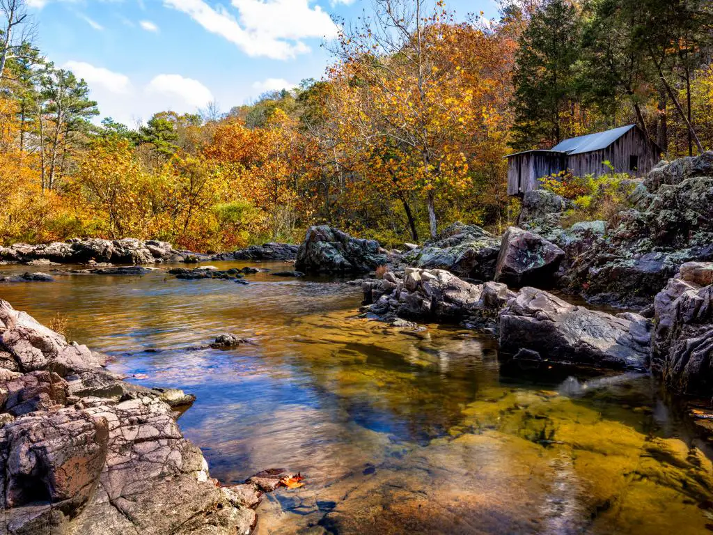Un molino de madera abandonado en las rocas junto a un río en el Bosque Nacional Mark Twain en otoño.