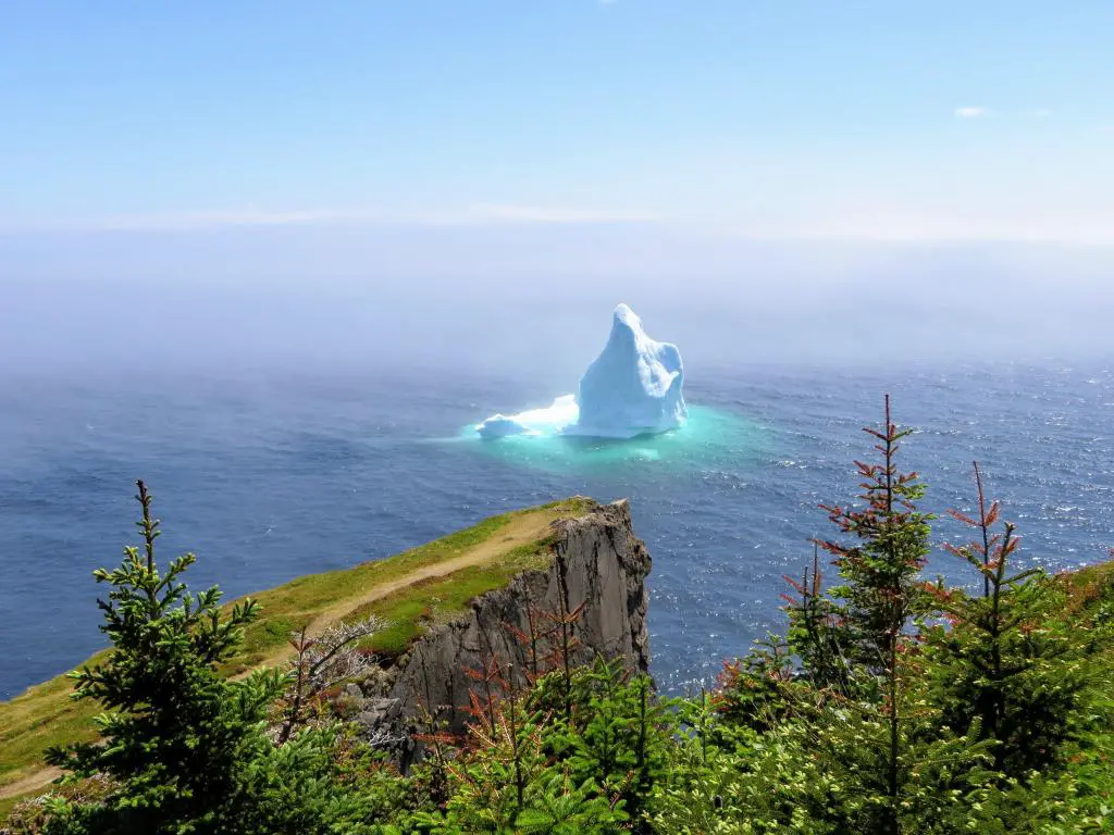 Increíble iceberg flotando a lo largo de la escarpada costa junto al Skerwink Trail en Terranova y Labrador, Canadá.