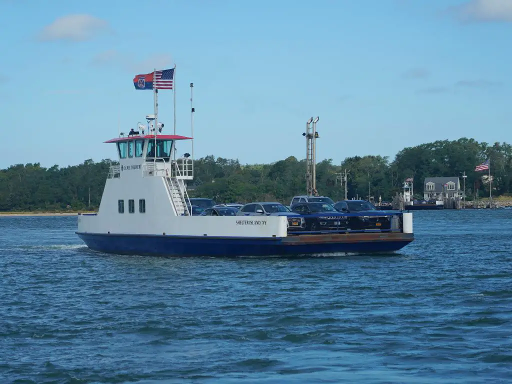 Un ferry que transporta automóviles y pasajeros desde Shelter Island hasta Sag Harbor en un día soleado.