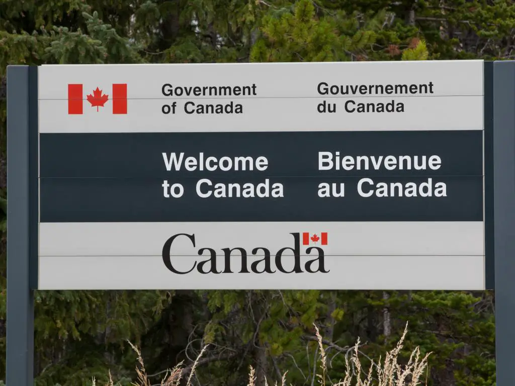 Firme en el cruce fronterizo entre los Estados Unidos y Canadá diciendo Bienvenido a Canadá.
