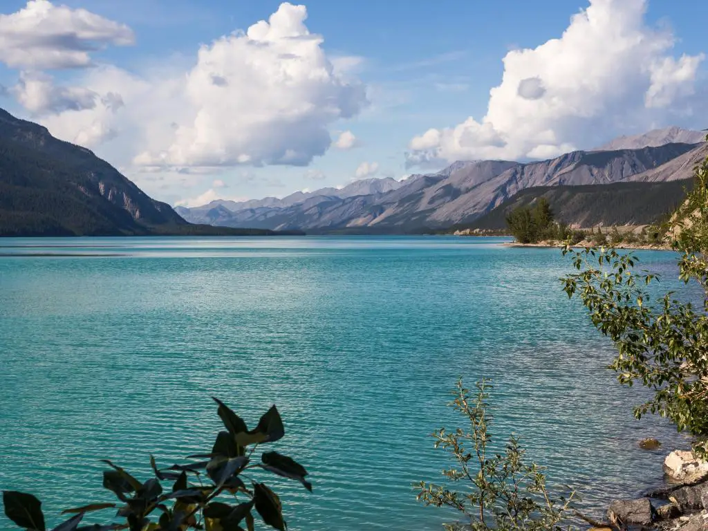 Lago Muncho en Columbia Británica, Canadá, con hermosas aguas turquesas y montañas a lo lejos. 