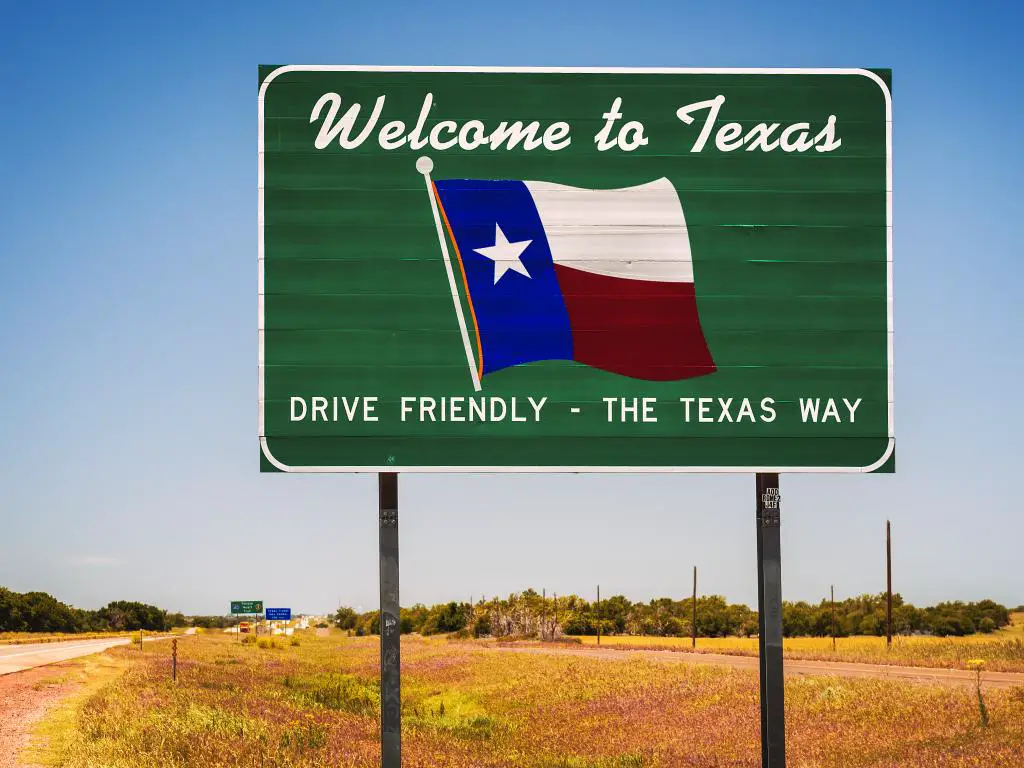 Bienvenido a la señal de tráfico de Texas en la frontera estatal que dice Drive Friendly - The Texas Way