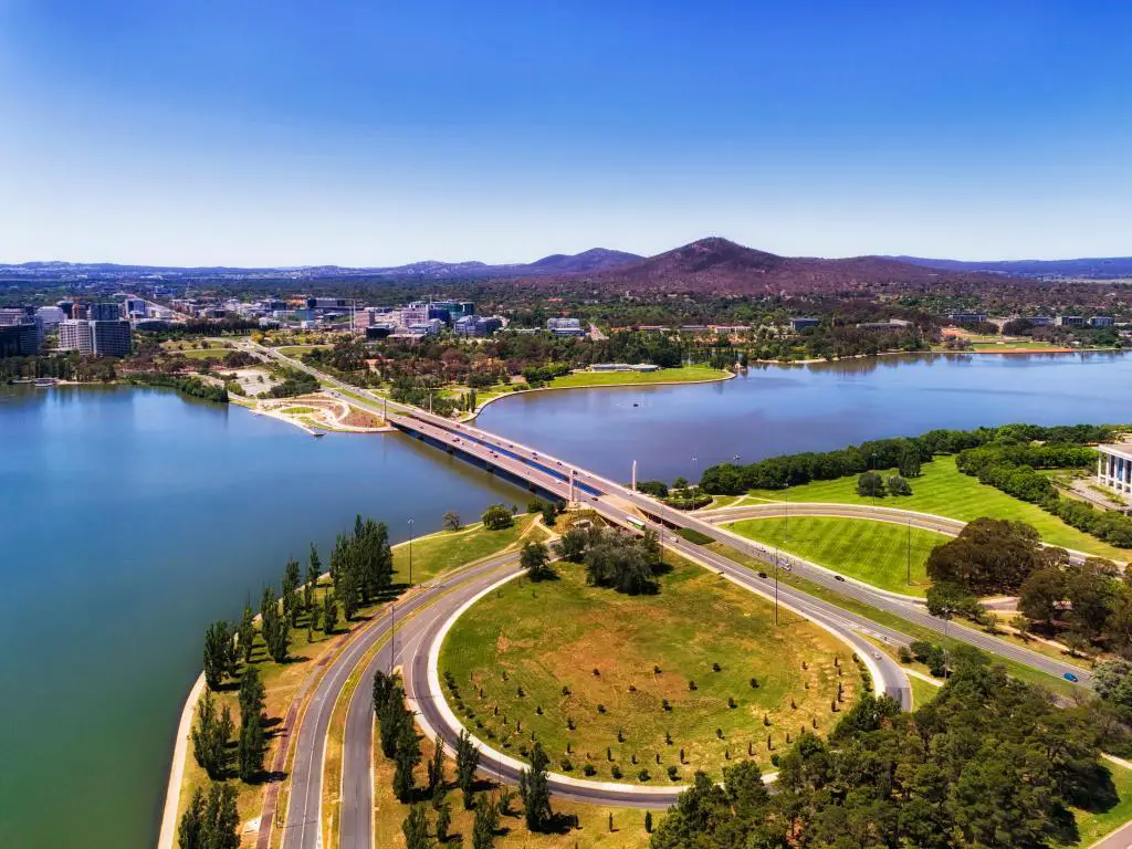 Canberra, Australia, con vistas a la avenida de la Commonwealth y al puente sobre el lago Burley Griffin en Canberra, entre el CDB de la ciudad y el área del triángulo de la colina de la capital del gobierno federal con calles, carreteras, parques y edificios locales.