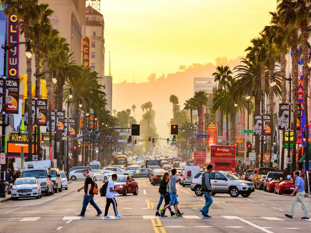 Personas y automóviles en el distrito de teatros de Hollywood Boulevard en Los Ángeles, California