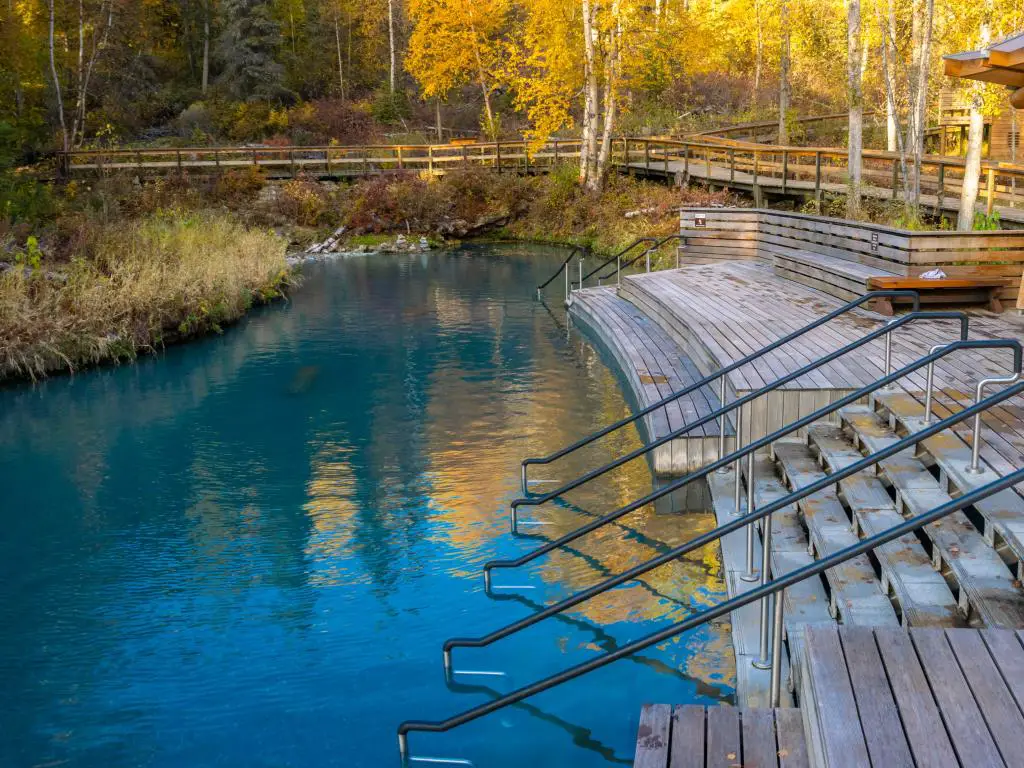 Las relajantes aguas cálidas de las aguas termales del río Liard con su plataforma de madera y escalones que bajan al agua.