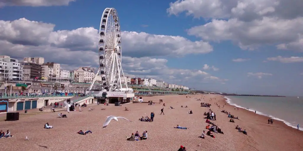 Una gaviota sobrevuela la playa de Brighton, con la rueda de la fortuna al fondo