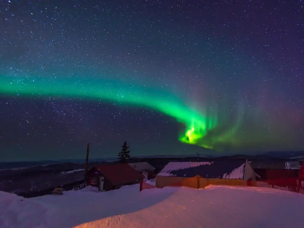 Fairbanks, Alaska con la aurora boreal, la aurora boreal, bailando sobre Fairbanks por la noche que está cubierta de nieve.
