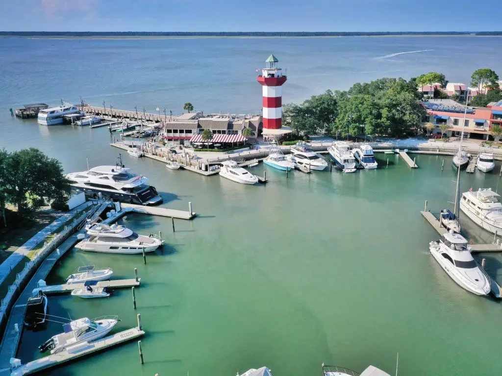 Hilton Head Island, Carolina del Sur, EE.UU. tomada en la ciudad portuaria con una vista aérea de los barcos amarrados en el puerto deportivo y un faro en el muelle.