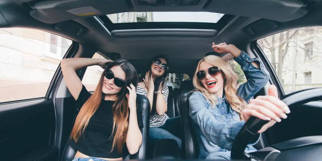 Tres chicas cantando en el coche.