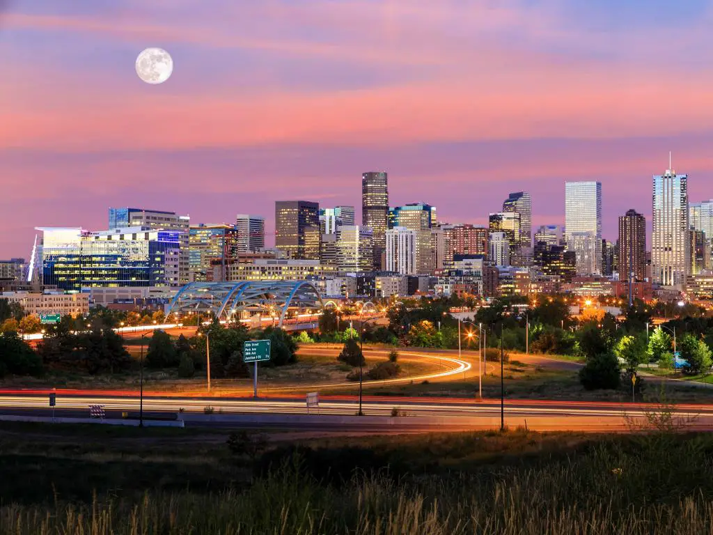Denver, Colorado, EE.UU. tomado como un panorama de la larga exposición del horizonte de Denver al atardecer con la luna arriba.