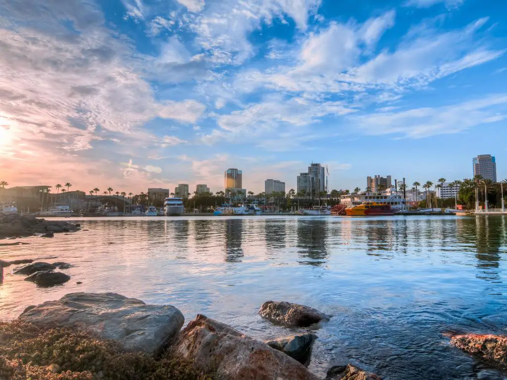 Long Beach, California, EE.UU., con vistas al puerto y las rocas en primer plano tomadas justo antes del atardecer.