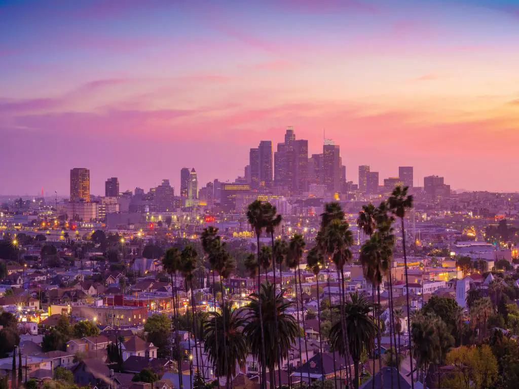 Los Ángeles, California, EE. UU. con una increíble vista de la puesta de sol con palmeras y el centro de Los Ángeles. 