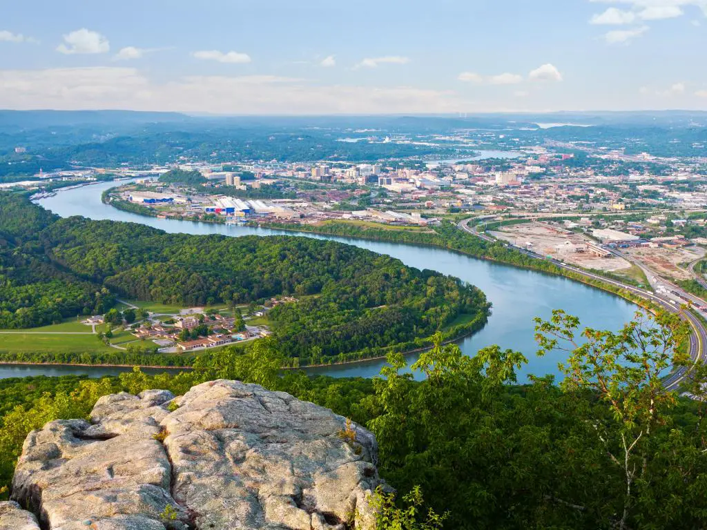 Chattanooga, Tennessee, EE.UU. tomada en la orilla del río en el centro de la ciudad como una vista aérea en un día soleado con rocas en primer plano. 