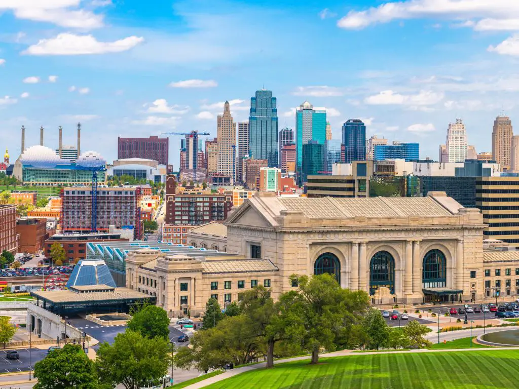 Kansas City, Missouri, EE.UU. El centro de la ciudad con Union Station y hierba en primer plano tomada en un día claro y soleado.