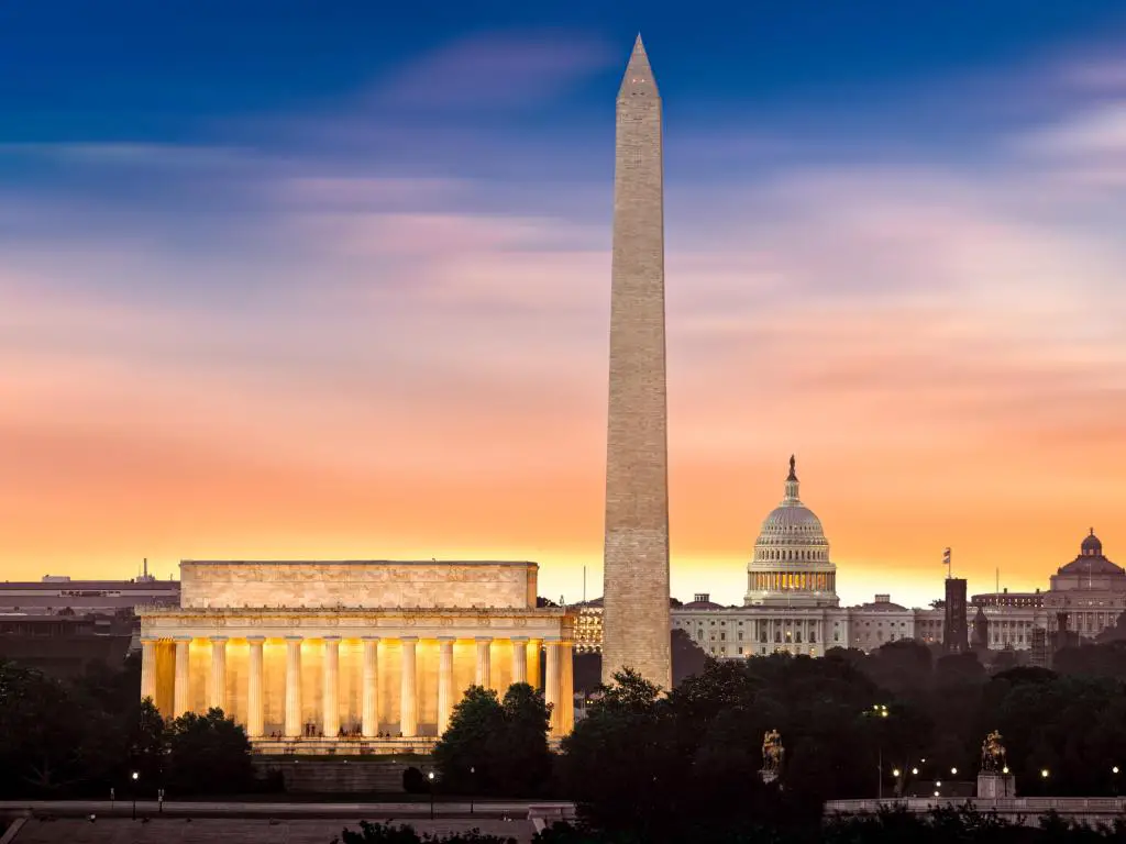 Washington, DC, EE.UU. tomada al amanecer sobre Washington con tres monumentos icónicos iluminados al amanecer: Lincoln Memorial, Washington Monument y Capitol Building.