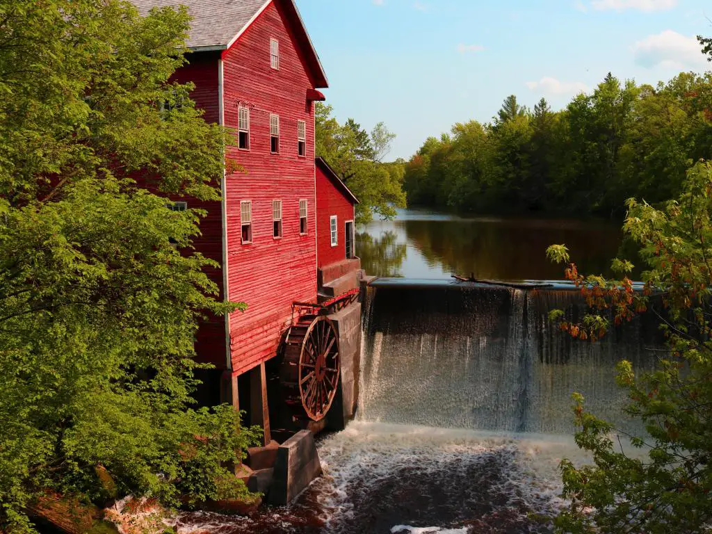Dells Mill, Wisconsin, EE. UU. Actualmente dirigido por Amish en Wisconsin con el molino rojo junto a una cascada tomada en un día claro y soleado.