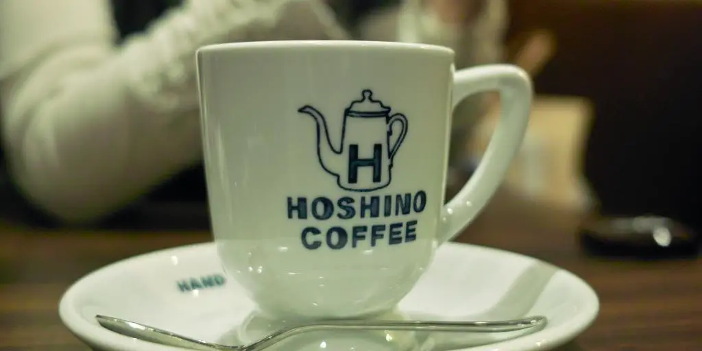 Una taza de café con leche con el logotipo de Hoshino Coffee en Tokio