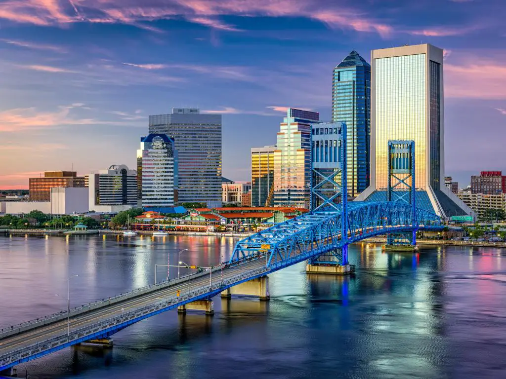 Jacksonville, Florida, EE.UU. con el horizonte del centro de la ciudad a lo lejos, el puente que cruza el río en primer plano y tomado al atardecer.