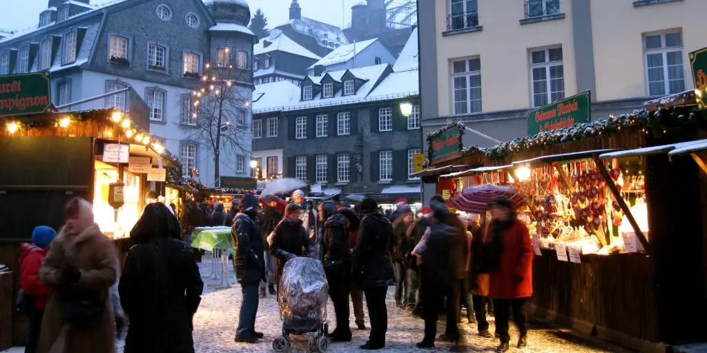 Casas nevadas y puestos en el mercado navideño de Monschau, Alemania 