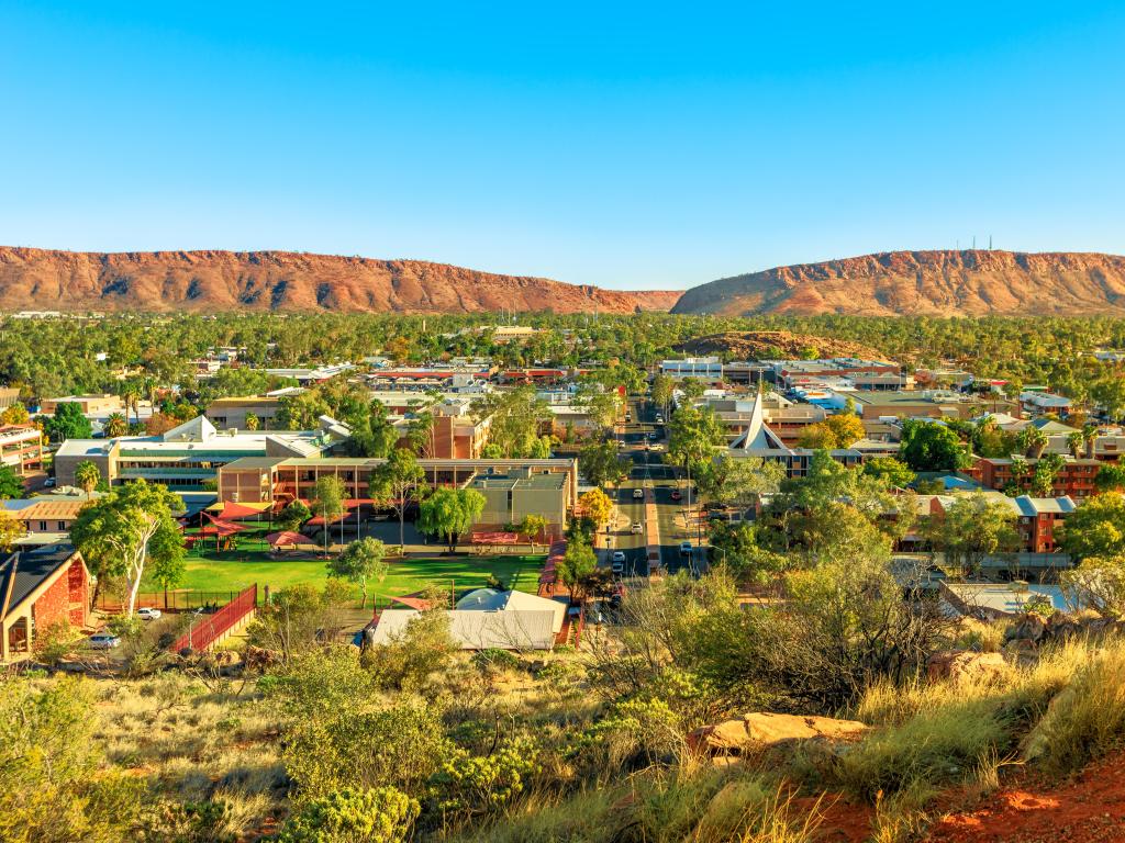 Alice Springs, Australia, con una vista aérea del horizonte de Alice Springs en Australia desde el mirador Anzac Hill Memorial con los principales edificios del centro de la ciudad de Alice Springs.  Desierto del Centro Rojo con cordilleras Macdonnell del Territorio del Norte.