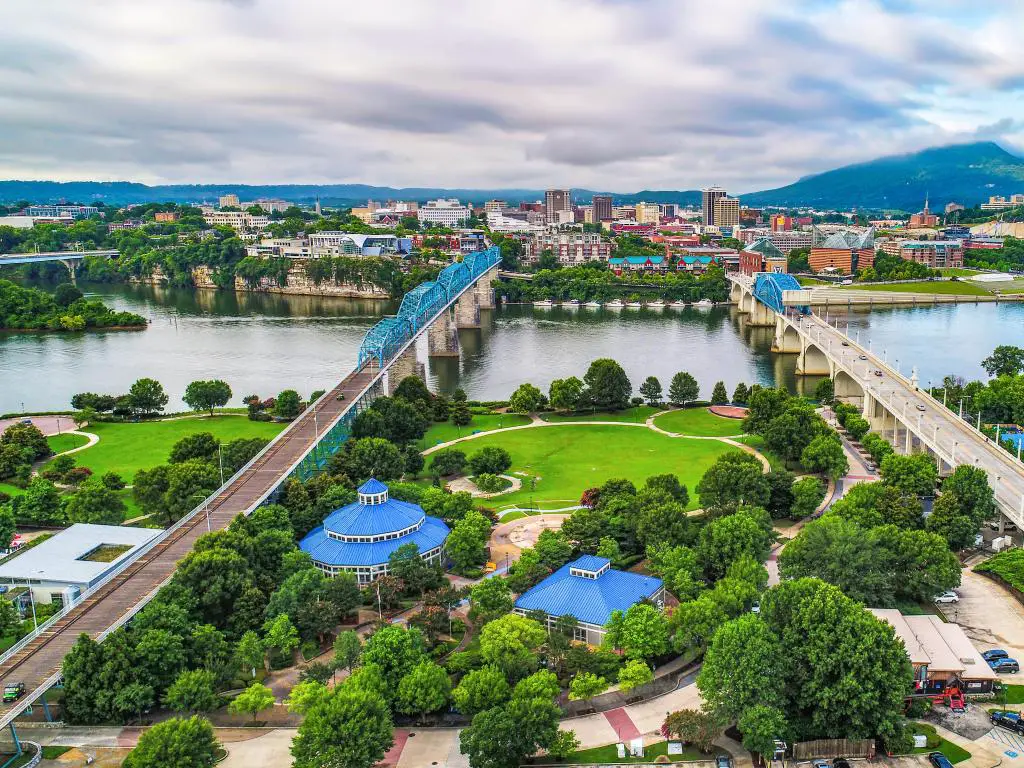 Chattanooga, TN, EE. UU. Con una vista aérea de drones del centro de Chattanooga con Coolidge Park y Market Street Bridge y montañas en la distancia.