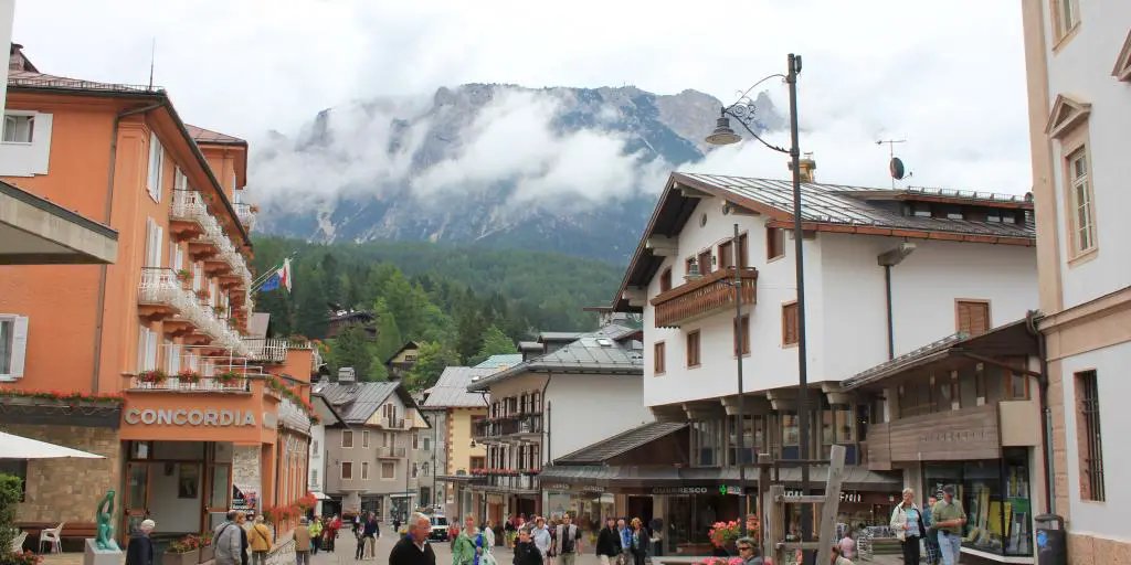 Compradores y visitantes caminan por el centro peatonal de esquí de Cortina d'Ampezzo, Italia