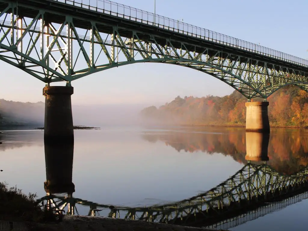 Río Kennebec, Rail Trail en otoño, la foto que representa el puente conmemorativo de Kennebec, Augusta, Maine, EE.UU. en un día soleado.