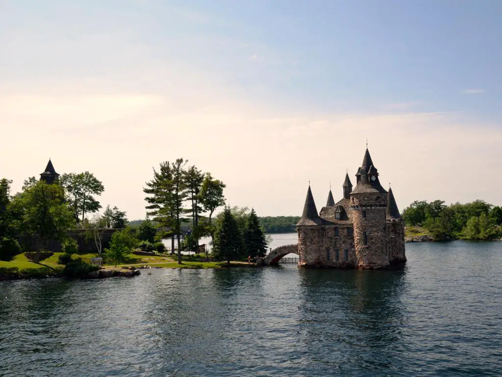 Río St. Lawrence, Ontario, Canadá, parte del crucero Thousand Islands con un castillo rodeado de agua justo antes del atardecer.