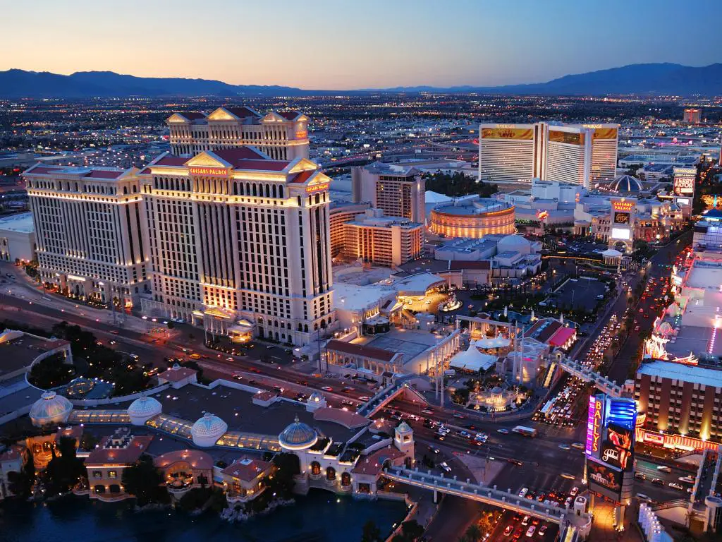 Las Vegas, Nevada, EE.UU. tomada como una vista aérea de la franja de Las Vegas por la noche con montañas en la distancia.