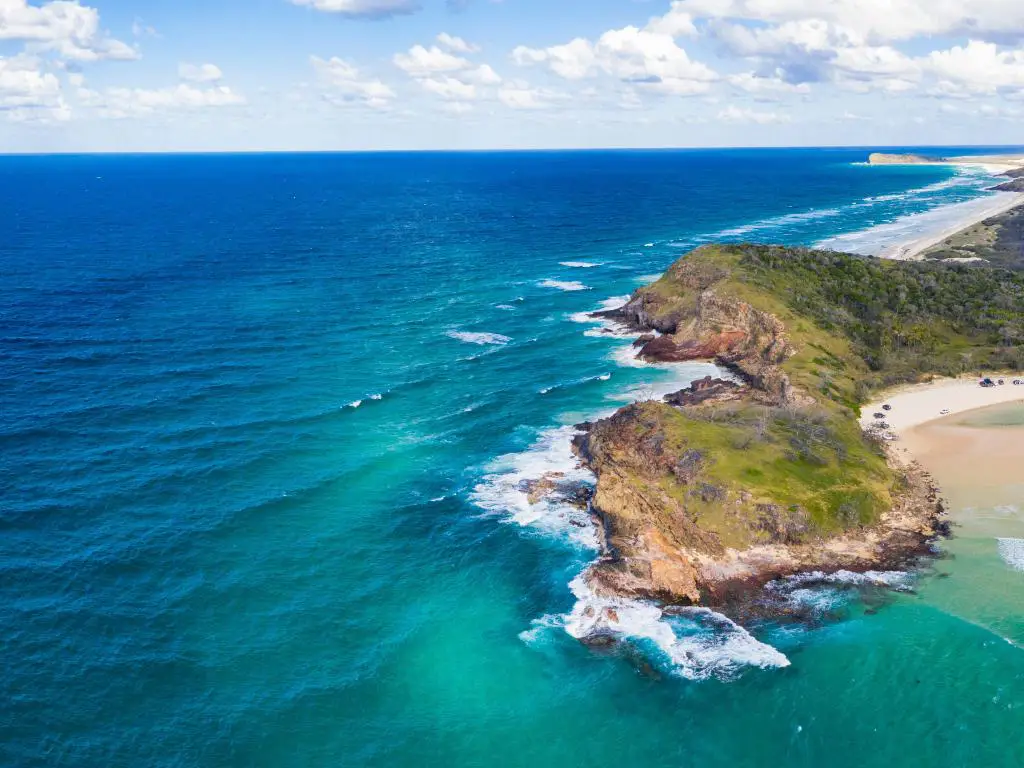 Fraser Island, Queensland una vista aérea de la impresionante isla con el océano que rodea la playa y un cielo azul. 