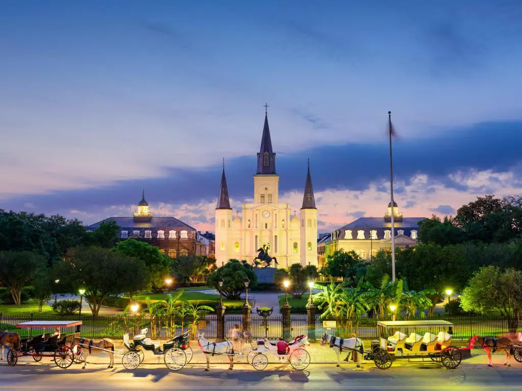 Nueva Orleans, Luisiana, EE.UU. en la Catedral de St. Louis y Jackson Square tomadas de noche con caballos y carretas en primer plano.