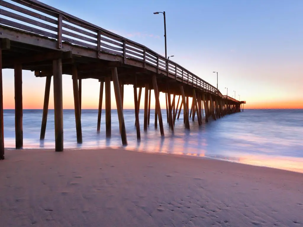 Virginia Beach, Virginia, EE.UU. tomada en el muelle de pesca al amanecer con arena suave y un mar en calma.