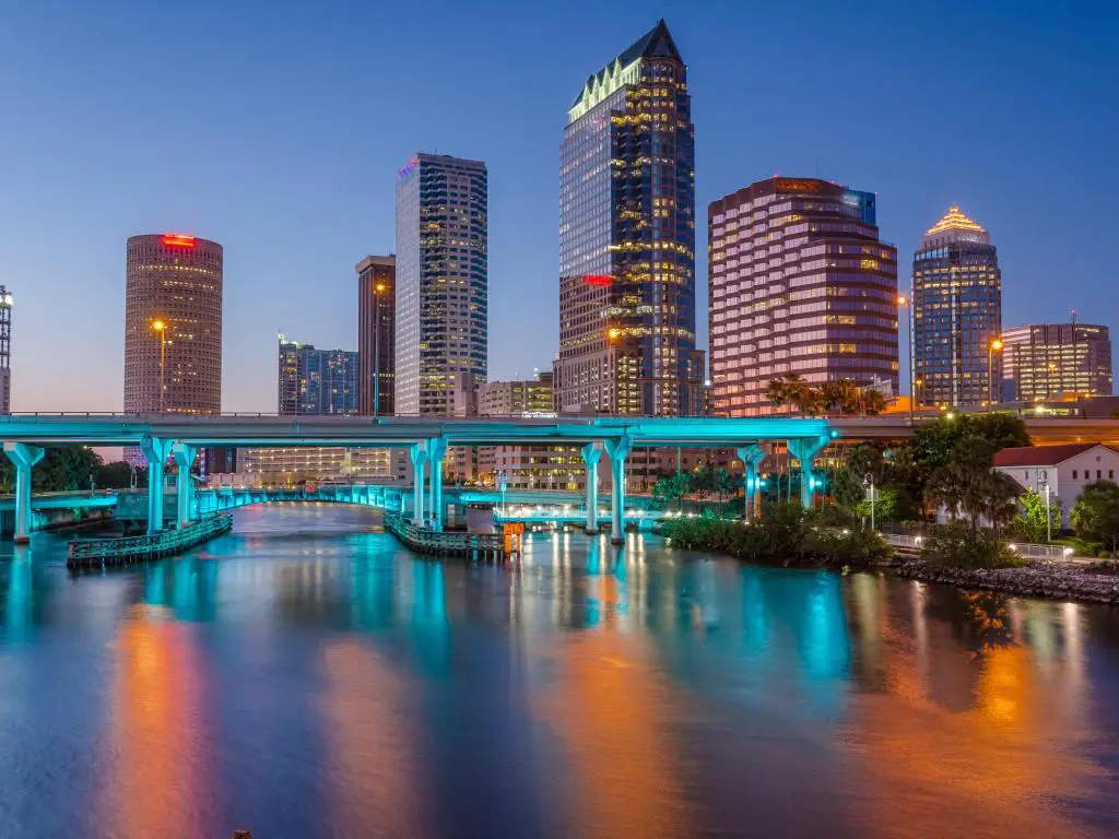 Tampa, Florida, EE.UU. con el centro de la ciudad por la noche, el puente iluminado y el río Hillsborough en primer plano.