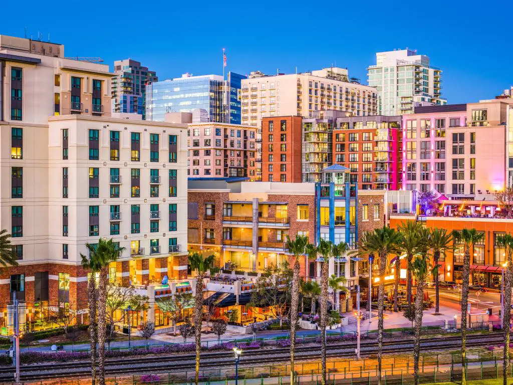 Paisaje urbano de San Diego, California, EE.UU. en el Gaslamp Quarter con palmeras en primer plano y tomada al atardecer.