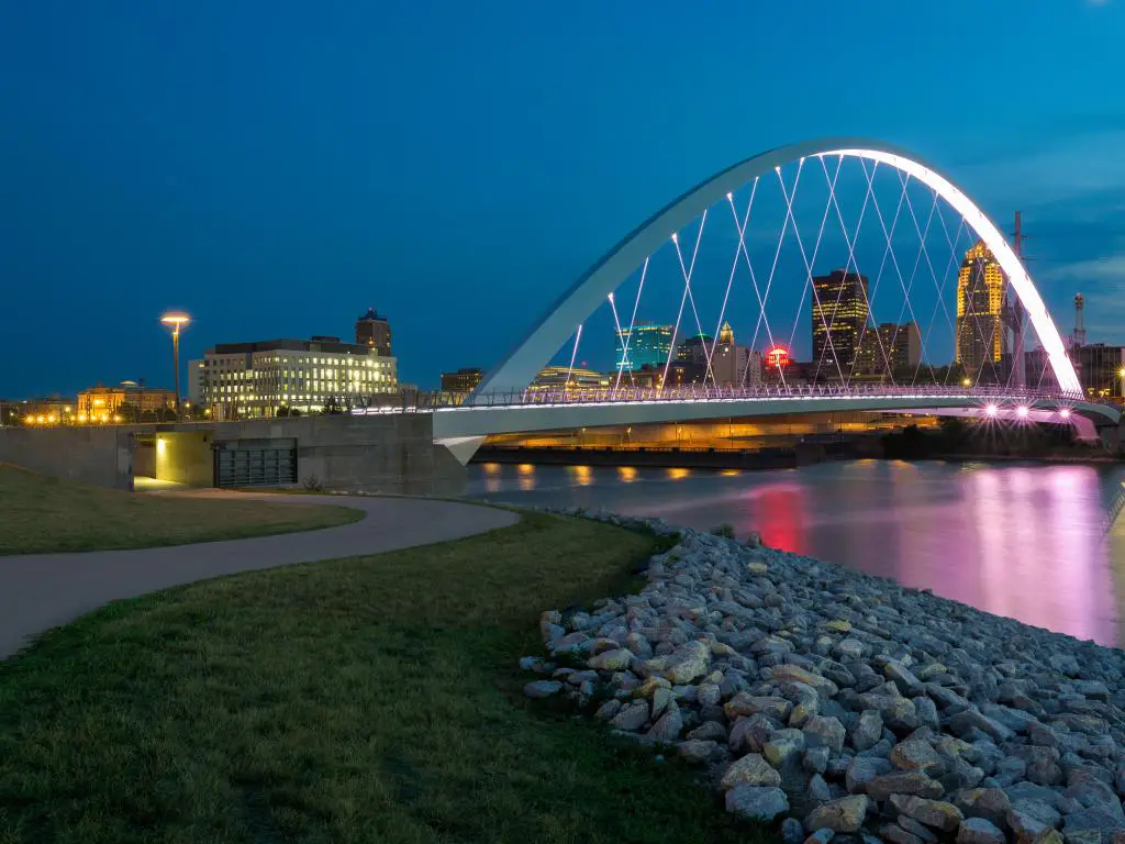 Des Moines, Iowa, EE.UU. Tomada en el Puente de Mujeres de Logro de Iowa que refleja el río Des Moines por la noche.