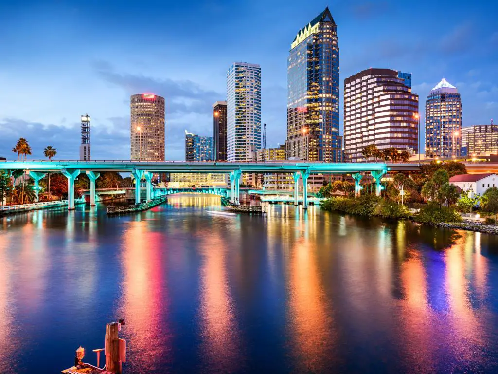El centro de Tampa, Florida, EE.UU. con el horizonte de la ciudad en la distancia y el río Hillsborough en primer plano tomado por la noche.