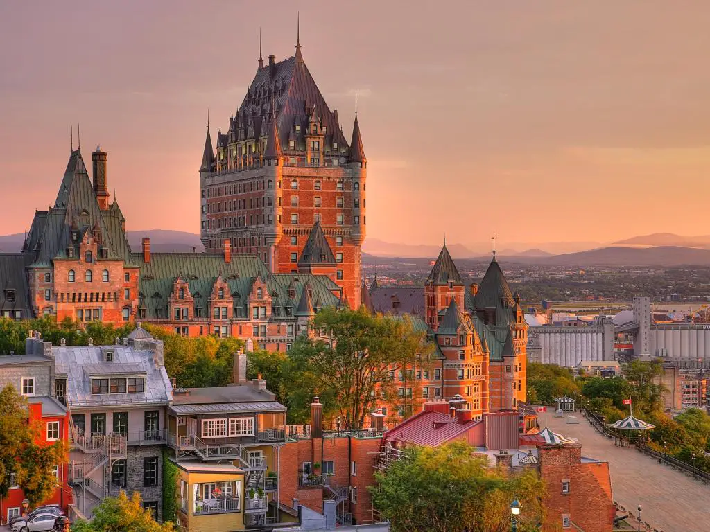 Old Quebec City, Quebec, Canadá, tomada en el castillo de Frontenac en Old Quebec City en la hermosa luz del amanecer con colinas en la distancia y coloridos edificios en primer plano. 