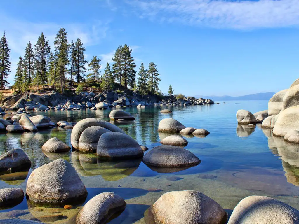 Lake Tahoe, EE.UU., tomada temprano en la mañana con rocas en Sand Harbor en primer plano y árboles en la distancia. 