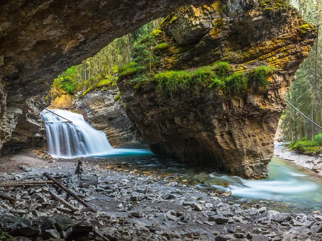Johnston Canyon, Lower Falls, Banff, Canadá, tomada en Waterfall Cave con grandes rocas que rodean el agua.