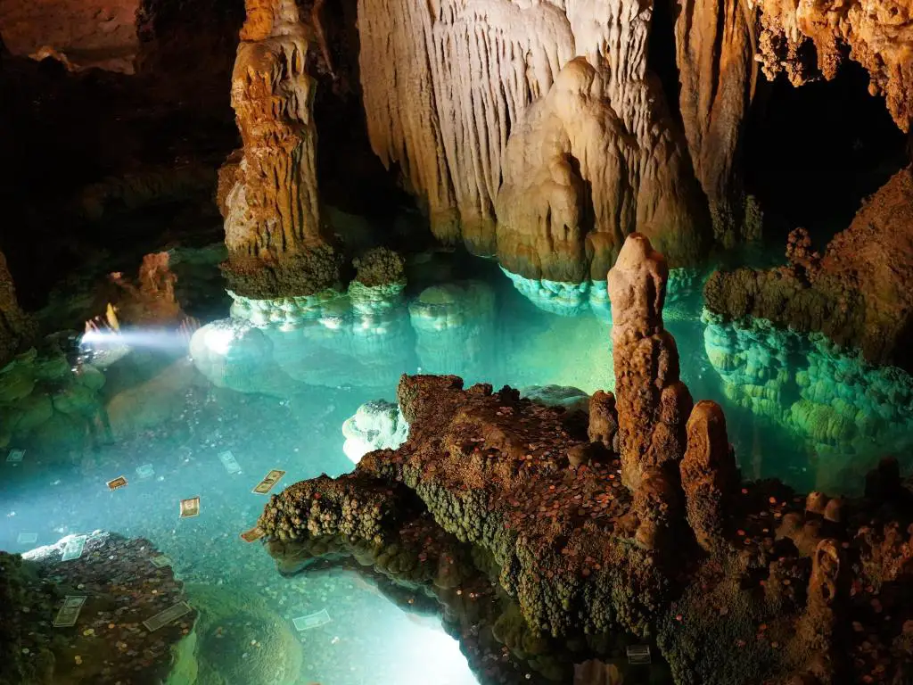 Cavernas de Luray, Virginia, EE.UU. tomadas en un pozo de los deseos con agua turquesa, dinero flotando y rodeado de formaciones rocosas.